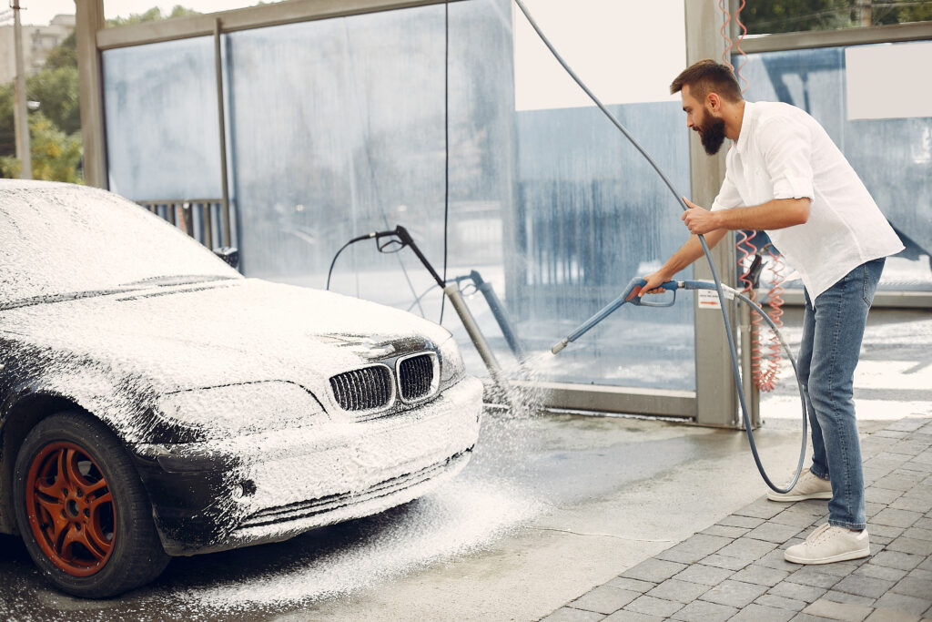 Man washing his car in a washing station